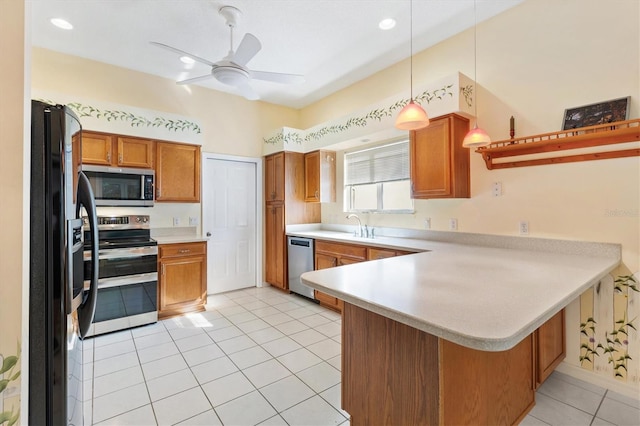 kitchen with appliances with stainless steel finishes, hanging light fixtures, kitchen peninsula, ceiling fan, and light tile patterned flooring