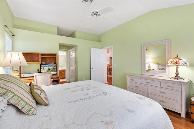 bedroom with ensuite bath, vaulted ceiling, light hardwood / wood-style floors, a baseboard heating unit, and ceiling fan