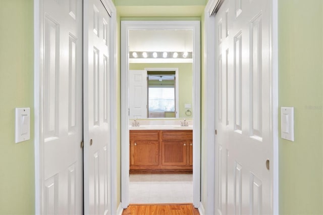 hall with light hardwood / wood-style floors and sink