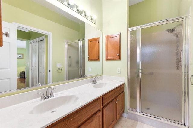 bathroom featuring a shower with door and vanity