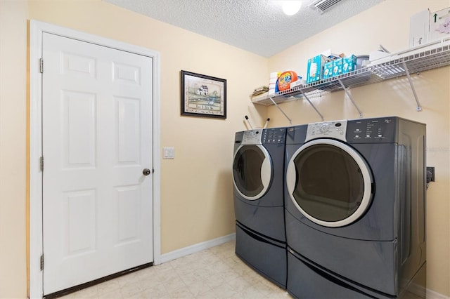 laundry area with a textured ceiling and washing machine and clothes dryer