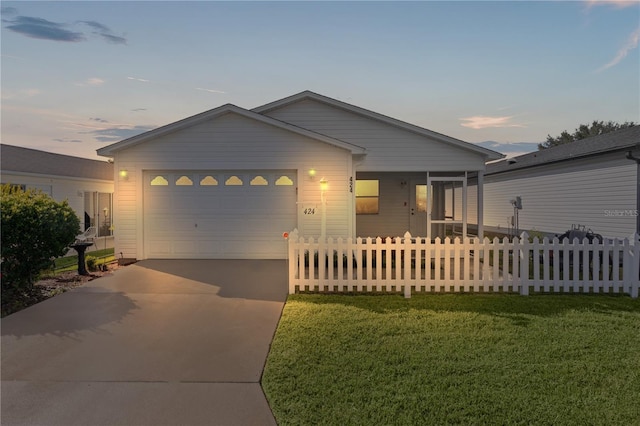 view of front of house featuring a garage and a yard