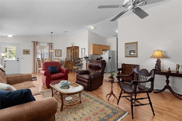 living room with light hardwood / wood-style floors, a textured ceiling, high vaulted ceiling, and ceiling fan