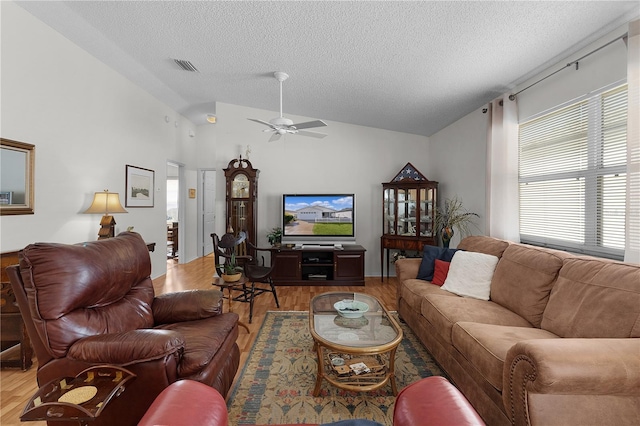 living room featuring a textured ceiling, light hardwood / wood-style flooring, ceiling fan, and vaulted ceiling