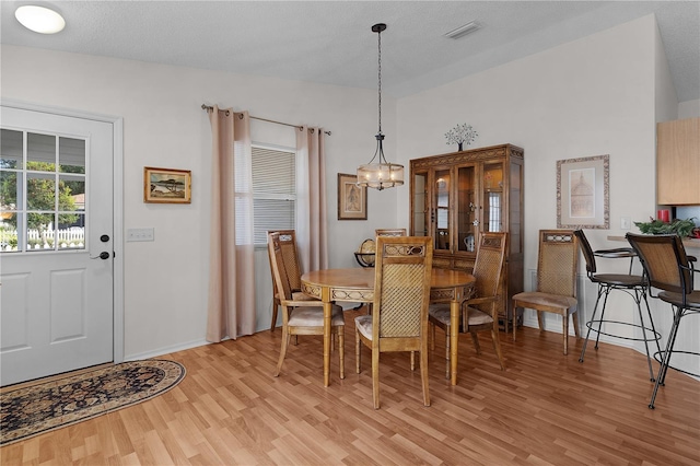 dining area featuring a notable chandelier and light wood-type flooring