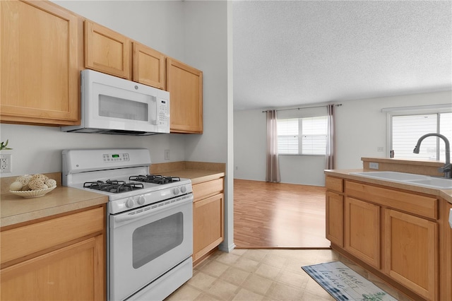 424 Rose Croft Ter, The Villages, FL 32162 - kitchen featuring white appliances, a sink, light floors, a textured ceiling, and light countertops