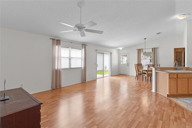 424 Rose Croft Ter, The Villages, FL 32162 - living area featuring a textured ceiling, ceiling fan, healthy amount of natural light, light wood finished floors, and lofted ceiling