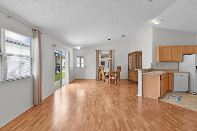 424 Rose Croft Ter, The Villages, FL 32162 - kitchen with lofted ceiling, white appliances, light wood-style flooring, a textured ceiling, and light countertops