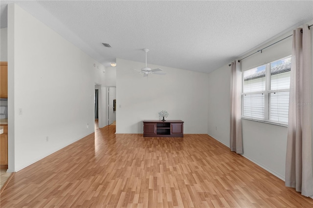 424 Rose Croft Ter, The Villages, FL 32162 - unfurnished living room with light wood-style floors, a textured ceiling, lofted ceiling, and ceiling fan