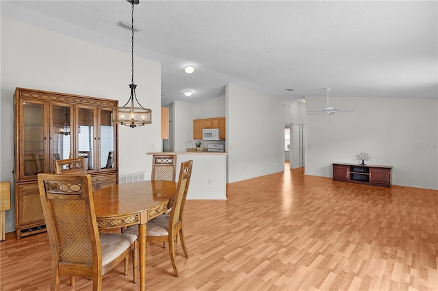 424 Rose Croft Ter, The Villages, FL 32162 - dining area with vaulted ceiling, light wood-style floors, a chandelier, ceiling fan, and a textured ceiling