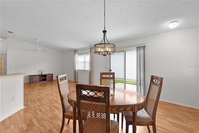 424 Rose Croft Ter, The Villages, FL 32162 - dining room with light wood-style flooring, a textured ceiling, a chandelier, vaulted ceiling, and a ceiling fan