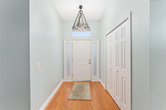 doorway featuring light hardwood / wood-style floors and a high ceiling