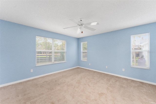 spare room featuring a textured ceiling, light colored carpet, and ceiling fan