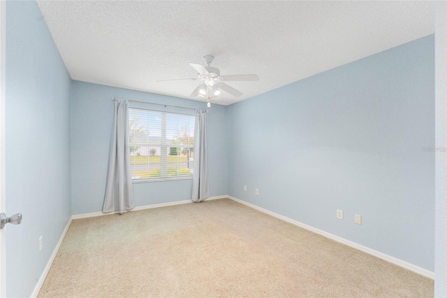 unfurnished room with ceiling fan, light colored carpet, and a textured ceiling