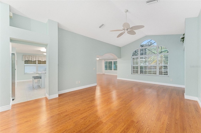 unfurnished living room featuring light wood-type flooring, vaulted ceiling, and ceiling fan