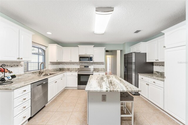 kitchen featuring sink, white cabinets, a center island, and appliances with stainless steel finishes