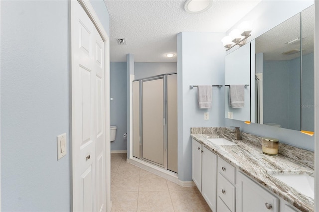 bathroom featuring vanity, toilet, tile patterned floors, and a shower with door