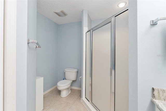 bathroom featuring a textured ceiling, toilet, walk in shower, and tile patterned floors