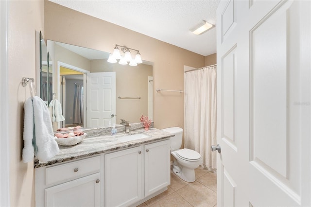 bathroom featuring vanity, toilet, tile patterned floors, and a textured ceiling