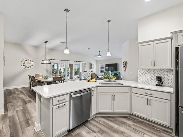 kitchen featuring pendant lighting, tasteful backsplash, sink, ceiling fan, and stainless steel dishwasher