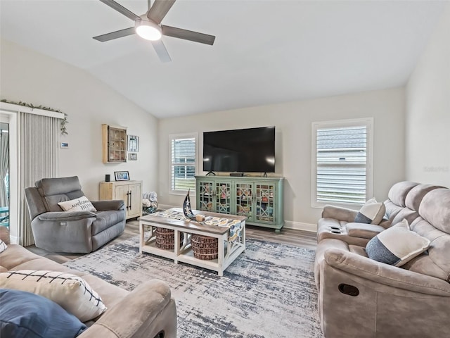 living room with ceiling fan, vaulted ceiling, a wealth of natural light, and hardwood / wood-style floors