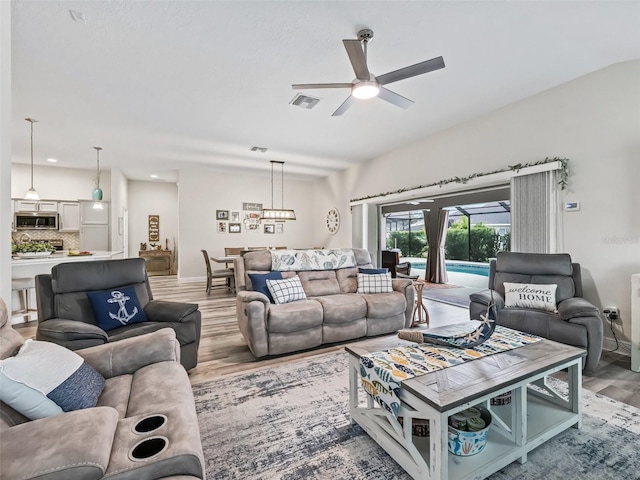 living room featuring ceiling fan and hardwood / wood-style flooring