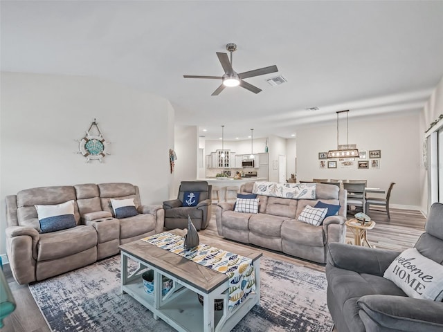 living room with ceiling fan and wood-type flooring