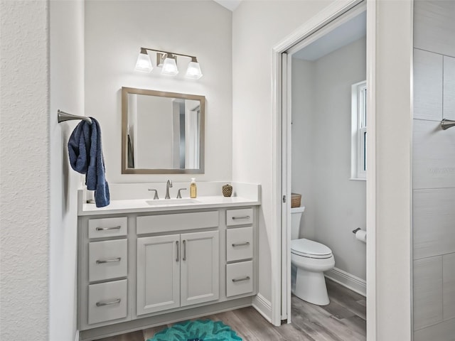 bathroom featuring toilet, vanity, and hardwood / wood-style floors