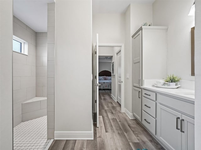 bathroom with vanity, tiled shower, and hardwood / wood-style floors