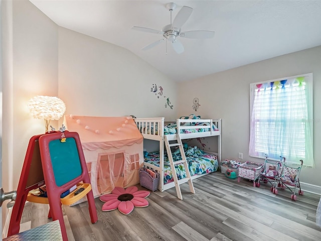 bedroom with ceiling fan, hardwood / wood-style flooring, and lofted ceiling