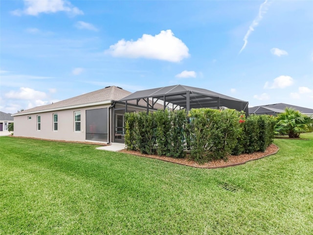 back of property with a lanai and a yard