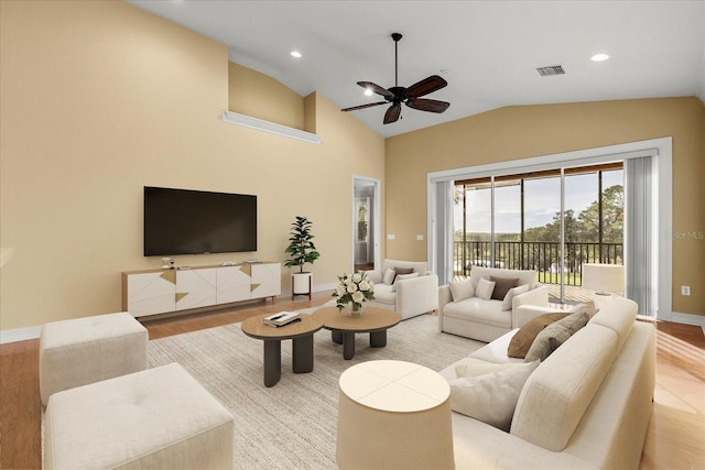 living room with light hardwood / wood-style flooring, ceiling fan, and vaulted ceiling