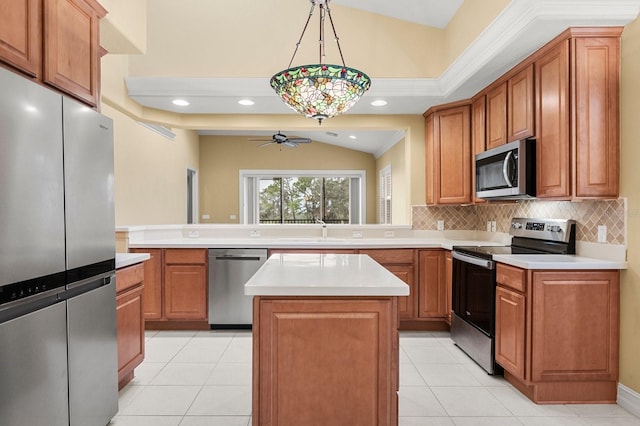 kitchen with appliances with stainless steel finishes, decorative light fixtures, a center island, and kitchen peninsula