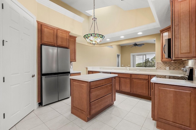 kitchen with light tile patterned flooring, appliances with stainless steel finishes, pendant lighting, backsplash, and a center island