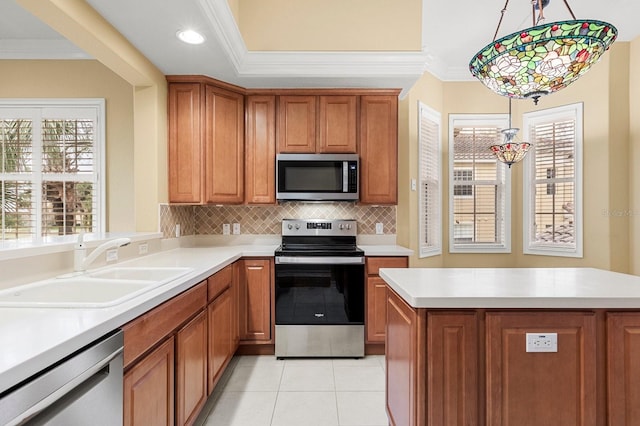 kitchen featuring sink, crown molding, hanging light fixtures, stainless steel appliances, and decorative backsplash