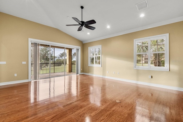 empty room featuring vaulted ceiling, light wood-type flooring, and a wealth of natural light