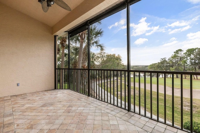 unfurnished sunroom featuring ceiling fan