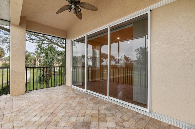 unfurnished sunroom featuring lofted ceiling and ceiling fan