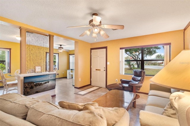 tiled living room with a textured ceiling and ceiling fan