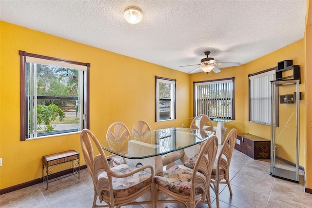 dining space with ceiling fan, a healthy amount of sunlight, light tile patterned floors, and a textured ceiling