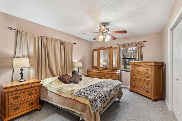 carpeted bedroom with a textured ceiling, a closet, and ceiling fan