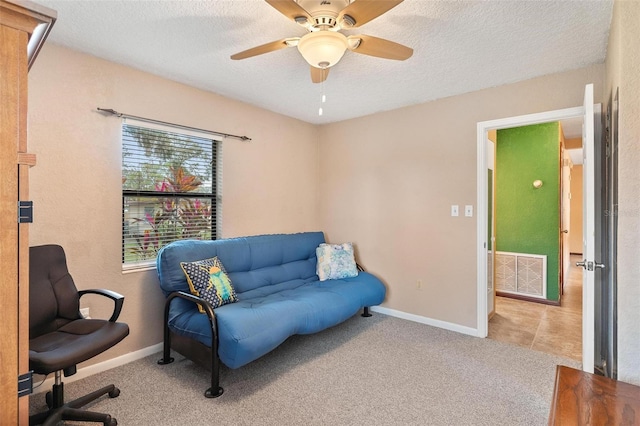 interior space with light colored carpet, a textured ceiling, and ceiling fan