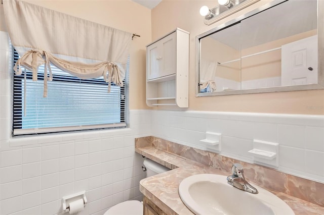 bathroom with vanity, tile walls, and toilet