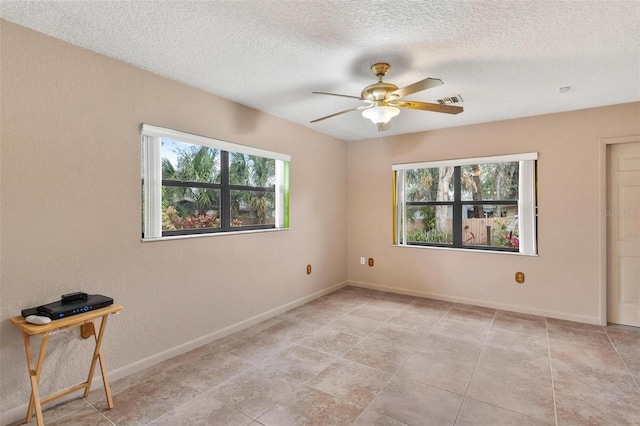 empty room with a textured ceiling and ceiling fan