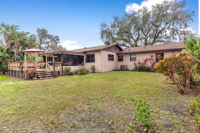 back of property with cooling unit, a wooden deck, a lawn, and a sunroom