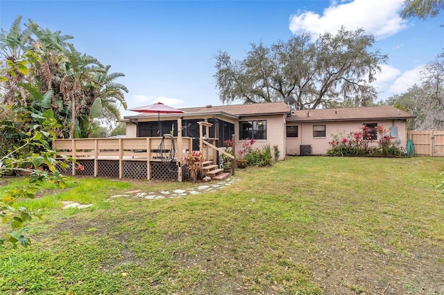 rear view of property featuring a wooden deck, a yard, central AC, and a sunroom