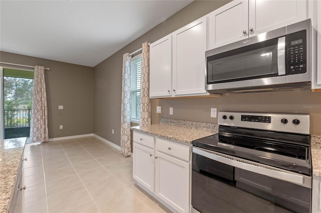 kitchen featuring light stone counters, plenty of natural light, white cabinetry, and appliances with stainless steel finishes