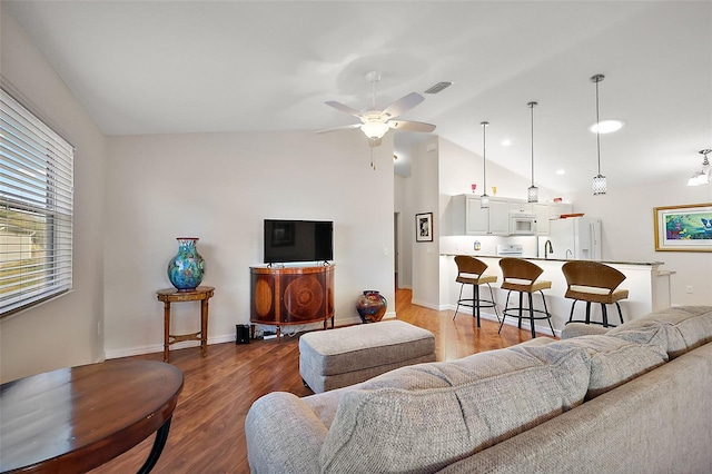 living room featuring ceiling fan, vaulted ceiling, and hardwood / wood-style flooring