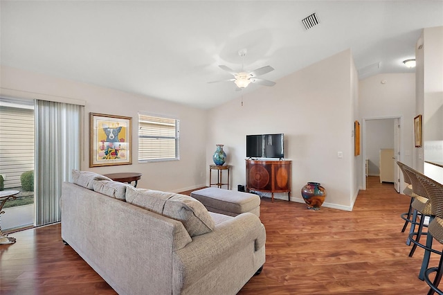 living room featuring hardwood / wood-style flooring, ceiling fan, and vaulted ceiling