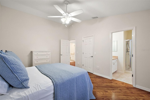 bedroom with ceiling fan, ensuite bathroom, and dark hardwood / wood-style floors